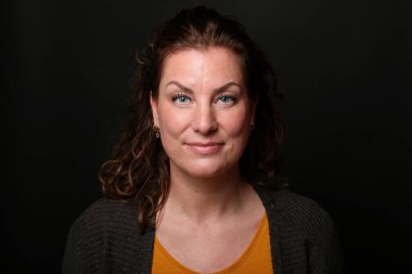 Güzel, mutlu bir kadının portresi. Renkli bir arka planın önünde.