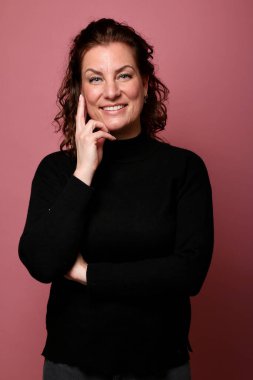 Güzel, mutlu bir kadının portresi. Renkli bir arka planın önünde.