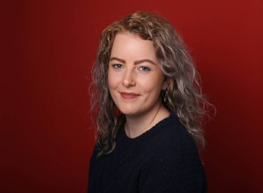 Güzel, mutlu bir kadının portresi. Renkli bir arka planın önünde.