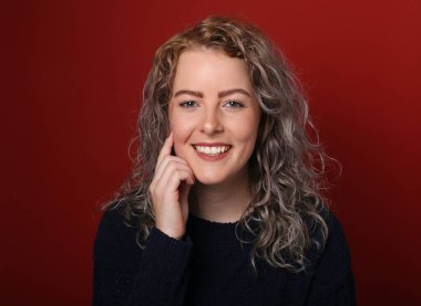 Güzel, mutlu bir kadının portresi. Renkli bir arka planın önünde.