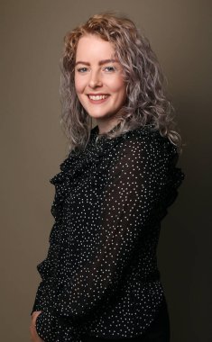 Güzel, mutlu bir kadının portresi. Renkli bir arka planın önünde.