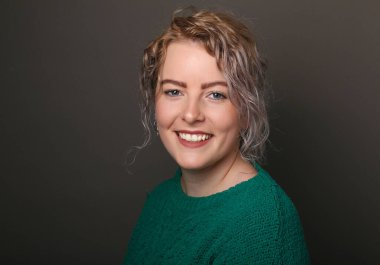 Güzel, mutlu bir kadının portresi. Renkli bir arka planın önünde.