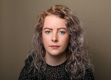 Güzel, mutlu bir kadının portresi. Renkli bir arka planın önünde.