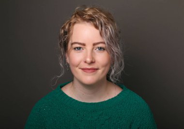 Güzel, mutlu bir kadının portresi. Renkli bir arka planın önünde.