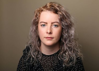 Güzel, mutlu bir kadının portresi. Renkli bir arka planın önünde.