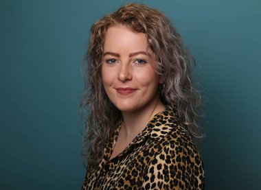 Güzel, mutlu bir kadının portresi. Renkli bir arka planın önünde.