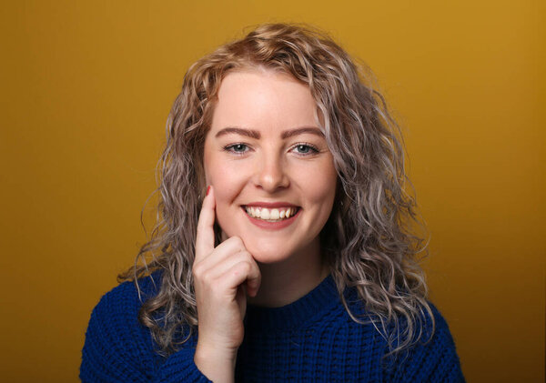 Portrait of a beautiful happy woman in front of a colored background