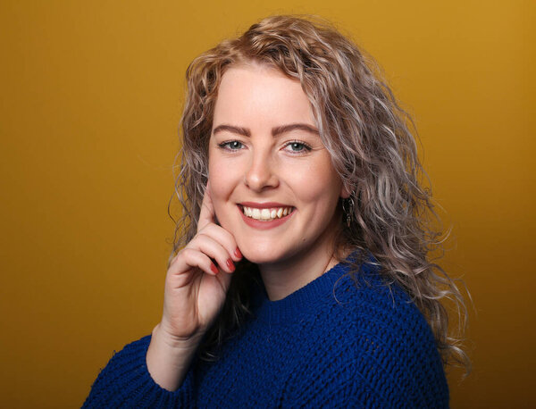 Portrait of a beautiful happy woman in front of a colored background