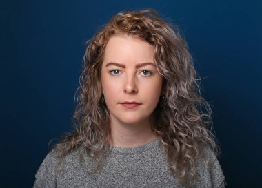 Güzel, mutlu bir kadının portresi. Renkli bir arka planın önünde.