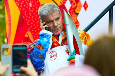 Russian singer, composer and poet Oleg Gazmanov participates in relay of Olympic Flame on October 29, 2013 in Svetlogorsk, Russia clipart