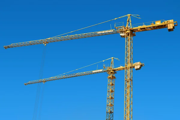 Tower cranes on a blue sky background — Stock Photo, Image