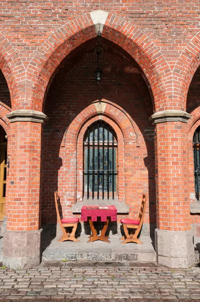 Table and chairs in a medieval arch — Stock Photo, Image