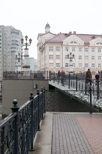 Kaliningrad. Blick auf die Fußgängerbrücke und Gebäude am Ufer des Flusses Pregolya. Russland — Stockfoto