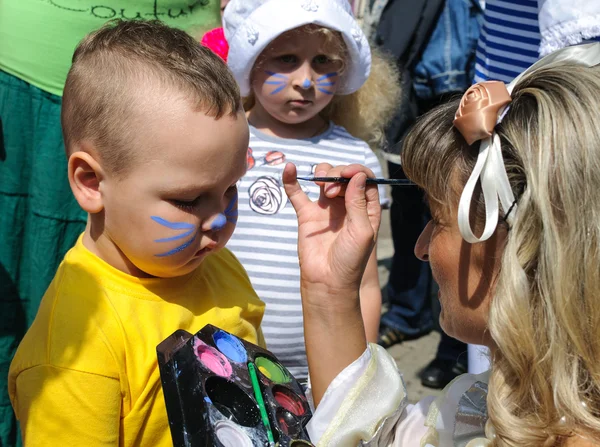 An unidentified child, painting at a boy's face on City Day of Kaliningrad celebration