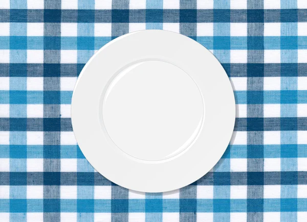 White plate on blue and white tablecloth — Stock Photo, Image
