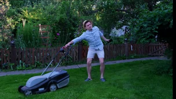 젊은이는 정원에서 잔디깎는 기계와 고품질 — 비디오