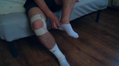 Futbol, tenis, voleybol, basketbol gibi aktif sporlar yaptıktan sonra bir adam dizliğini çıkarıyor. Yara rehabilitasyonu. Yüksek kalite 4k görüntü