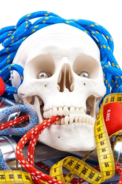 Fitness equipment and human scull — Stock Photo, Image