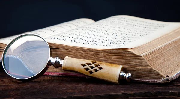 Oud boek en vergrootglas — Stockfoto