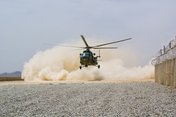 Helicopter landing in cloud of dust