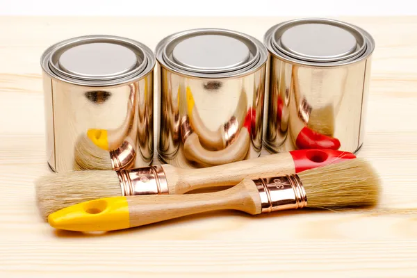 Cans of paint with paintbrushes isolated on white — Stock Photo, Image