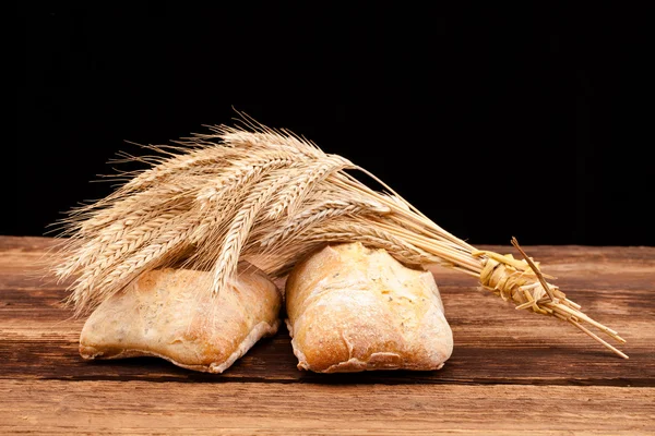 Pão assado na mesa de madeira — Fotografia de Stock