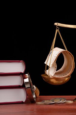 Hukuk kitapları, para, Büyüteç ve adaletin terazisi