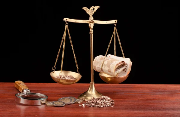 Деньги, увеличительное стекло и весы правосудия — стоковое фото