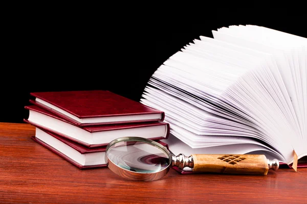Books of justice and magnifying glass — Stock Photo, Image