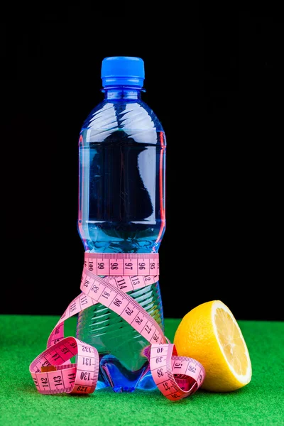 Бутылка воды и измерительная лента — стоковое фото