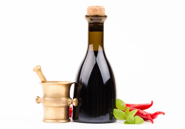 Bottle of vinegar and brass mortar with spices — Stock Photo, Image
