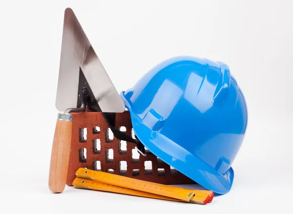 Hardhat, tijolo e pedreiro ferramentas — Fotografia de Stock