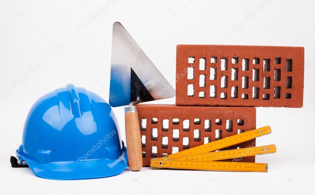 Blue hardhat, bricks and mason tools