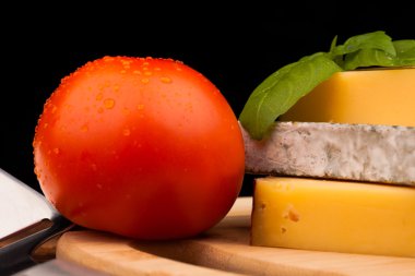 peynir ve domates izole siyah ahşap masa üzerinde çeşitli