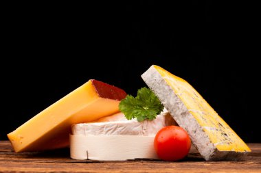 Tahta masada çeşitli peynir türleri var.