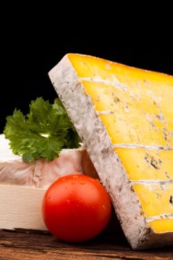 Tahta masada çeşitli peynir türleri var.