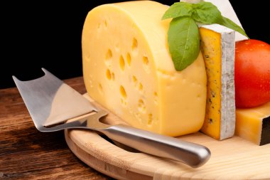 Tahta masada çeşitli peynir türleri var.