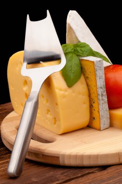 Tahta masada çeşitli peynir türleri var.