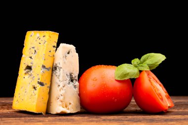 Tahta masada çeşitli peynir türleri var.