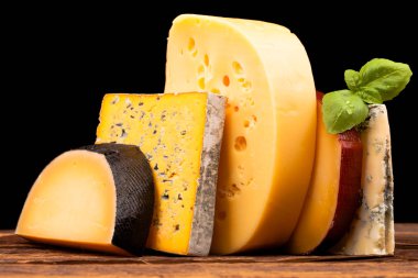 Tahta masada çeşitli peynir türleri var.