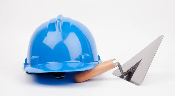 Blue hardhat, and mason trowel — Stock Photo, Image