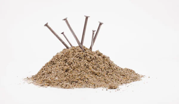 Sand pile and nails — Stock Photo, Image