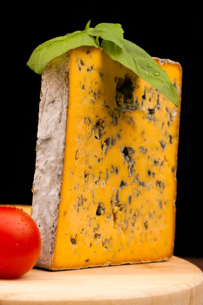 Various types of cheese and tomato on wooden table isolated on black — Stock Photo, Image