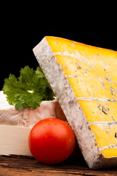 Tahta masada çeşitli peynir türleri var.