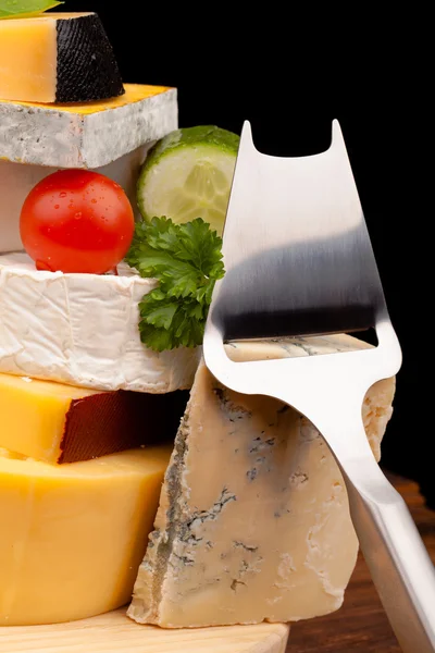Tahta masada çeşitli peynir türleri var.