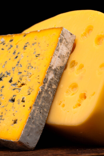 Various types of cheese on wooden table