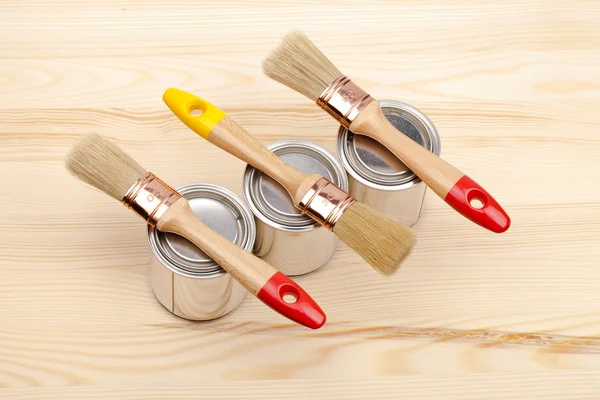 Cans of paint with paintbrushes — Stock Photo, Image