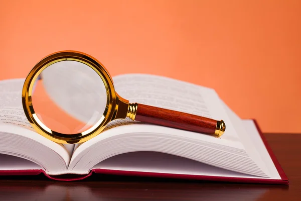 Book and magnifying glass — Stock Photo, Image