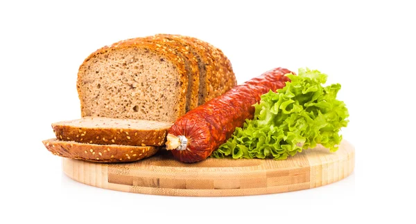 Pane e salsicce affumicate su piastra di legno — Foto Stock