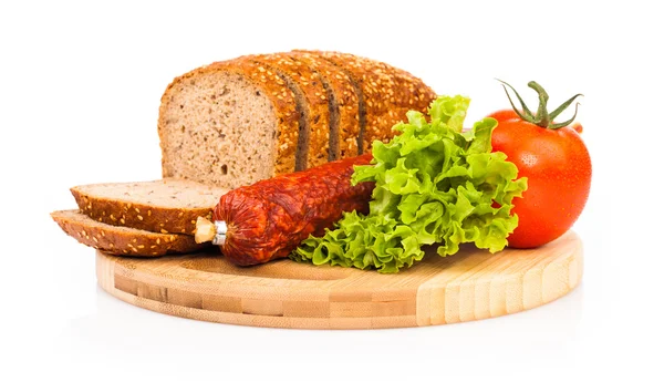 Bread and smoked sausages on wooden plate — Stock Photo, Image